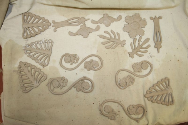 Vytlačené ornamenty z bielej hliny pred lepením na kachlicu