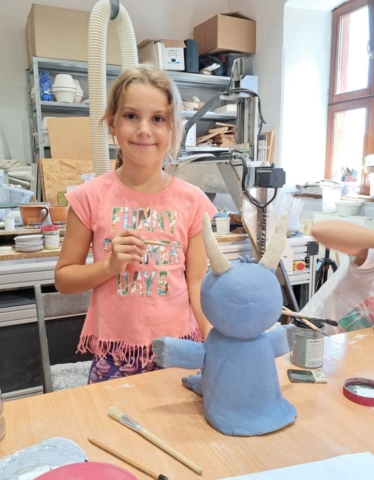 Lili dokončuje posledné detaily malým štetcom